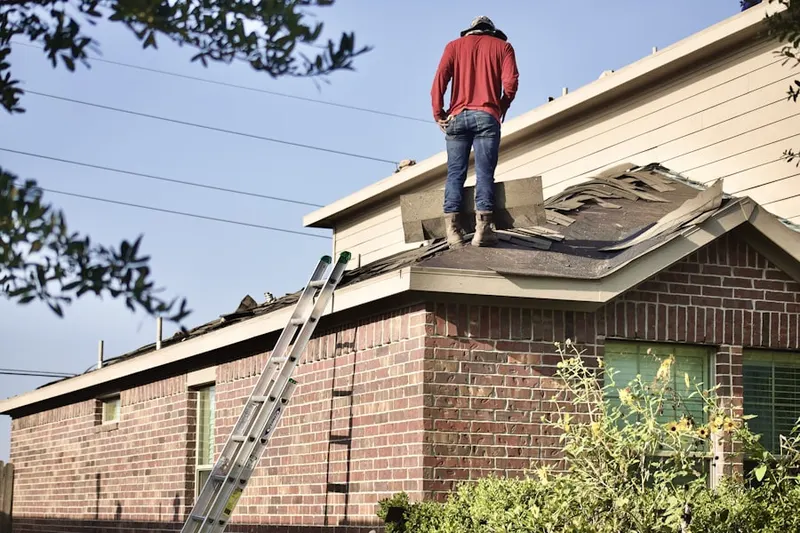 Professional roofer working on a residential roof in Locust Valley